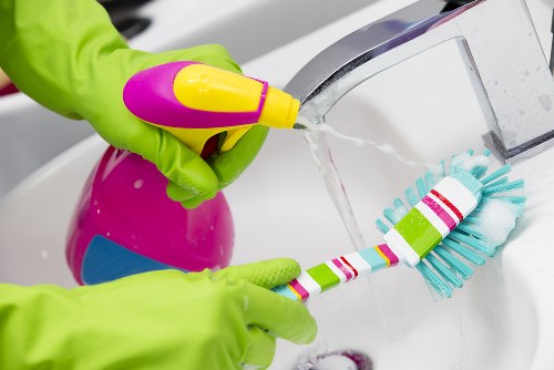 Cleaning professional in Harrow using safety equipment in a home setting